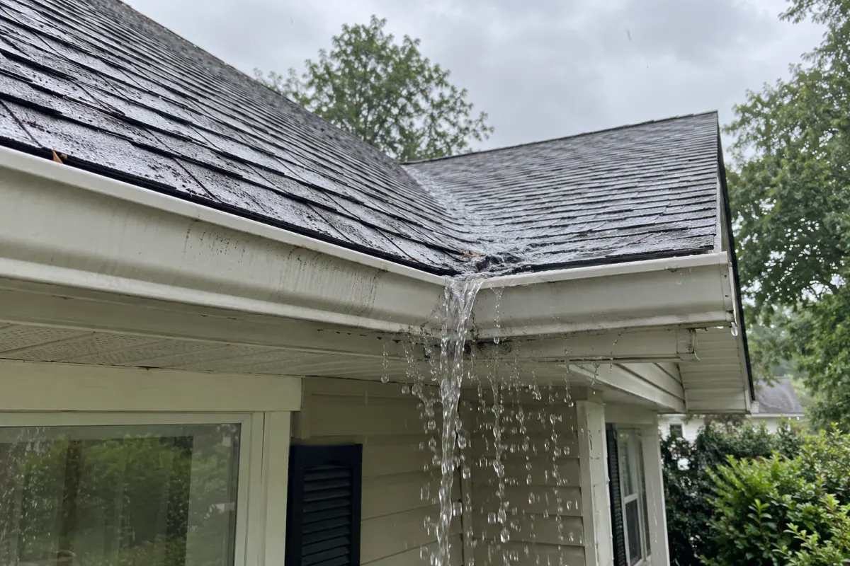Illustrative example of rainwater spilling over a gutter below a roof valley
