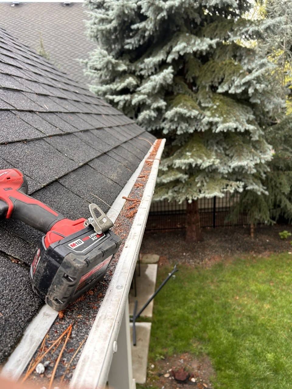 Trough being cleared by hand and checked for standing water during a gutter cleaning visit