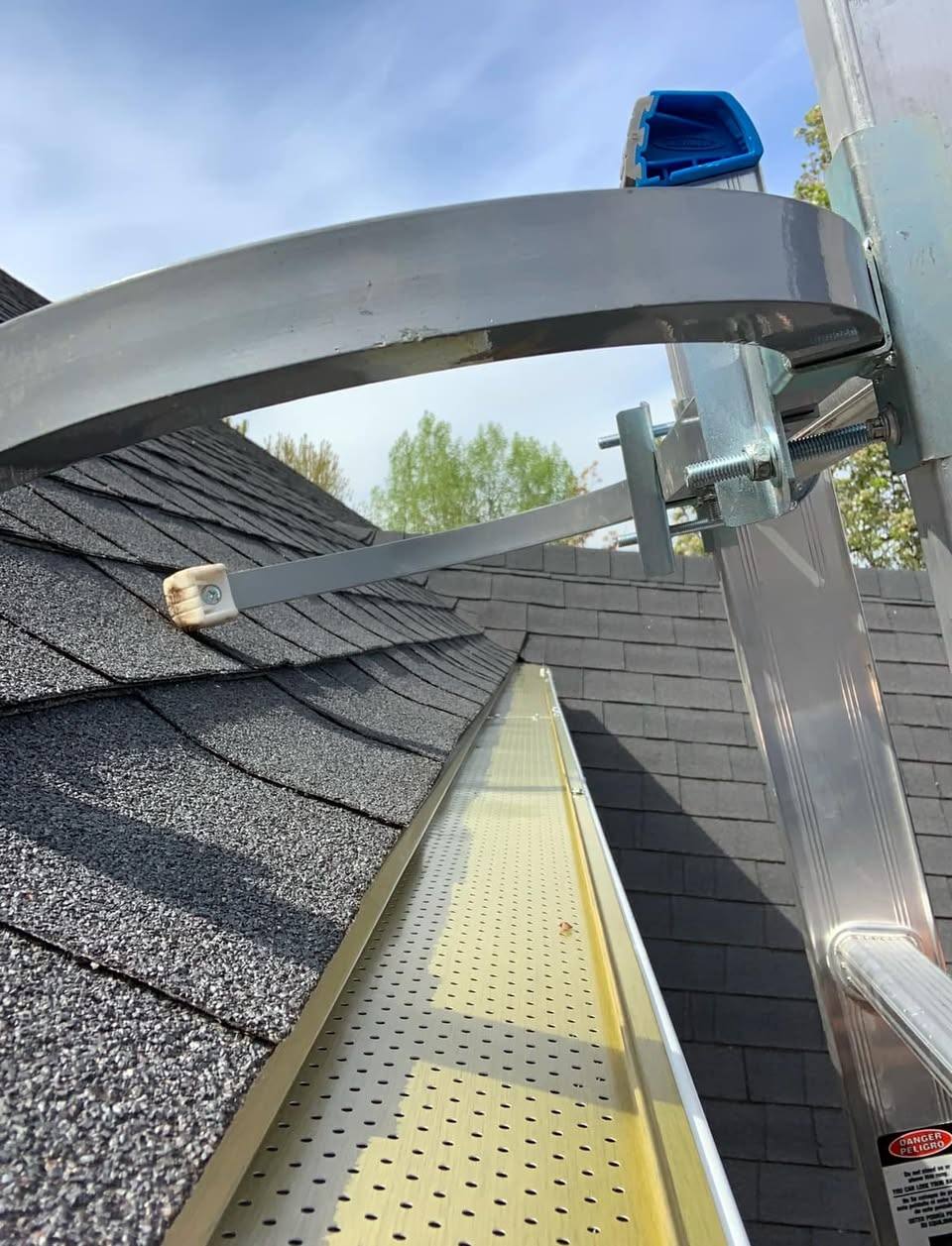 Rigid gutter guard being fitted along the edge of a Treasure Valley roof