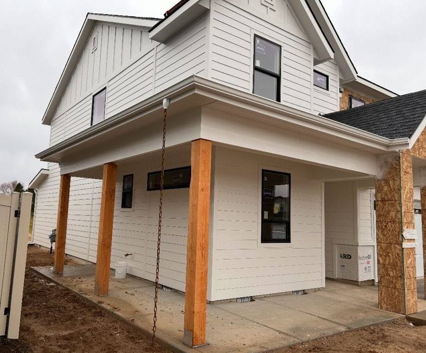 New construction home with porch columns and freshly hung seamless gutter
