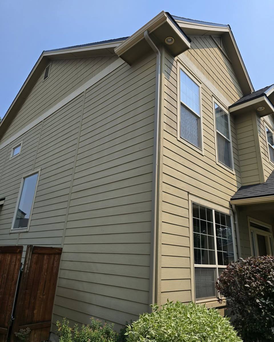 Gutter and downspout running down the garage side of a tan home